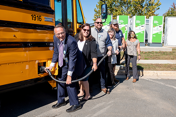 FCPS Superintendent Scott Brabrand and other FCPS employees plug in their electric school bus