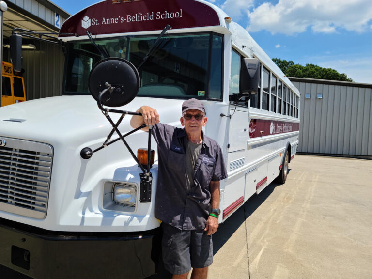 John Evans standing with the last bus he painted at Sonny Merryman